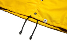 Load image into Gallery viewer, Yellow Coach Jacket with Black Logo,  Front View of the bottom branded hem tag, waist draw string and buttons.