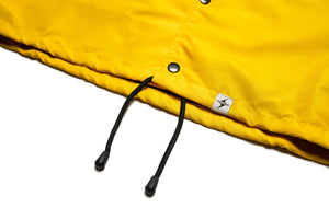 Yellow Coach Jacket with Black Logo,  Front View of the bottom branded hem tag, waist draw string and buttons.